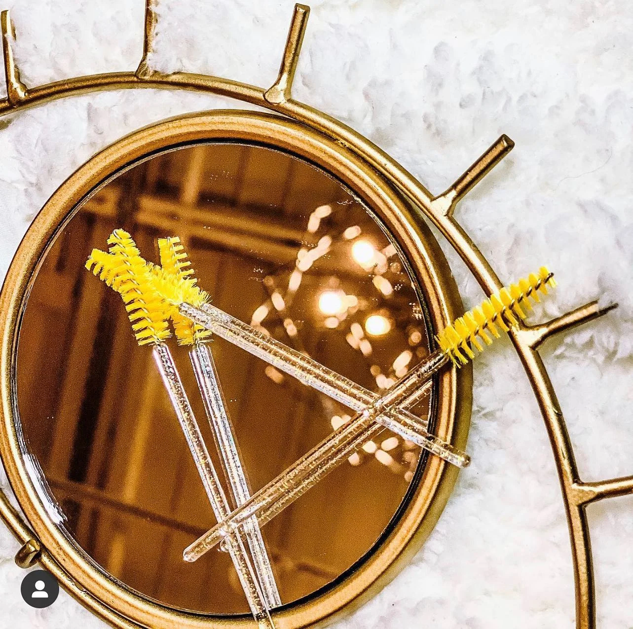 Gold lash mirror and artist brushes — tools of the craft